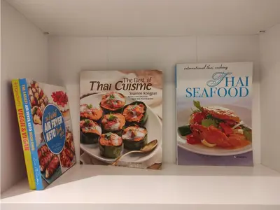 three books sitting on a shelf with food on them at Luxe Design l Wellness & Tropical Retreat l No fee in Bangkok