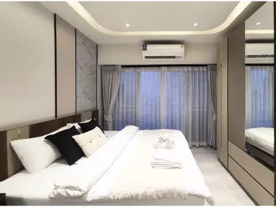 a bedroom with a large white bed and a window at Luxe Design l Wellness & Tropical Retreat l No fee in Bangkok