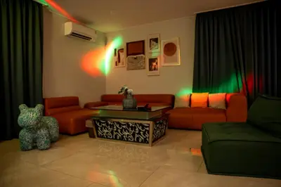 a living room with orange furniture and green lights at 944summer villa曼谷中心Asok&Tong Lor800海天别墅 in Bangkok