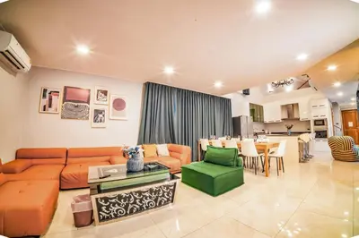a living room with an orange couch and a green chair at 944summer villa曼谷中心Asok&Tong Lor800海天别墅 in Bangkok