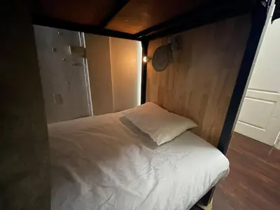 a small bed in a room with a wooden wall at Happy Hope in Bangkok