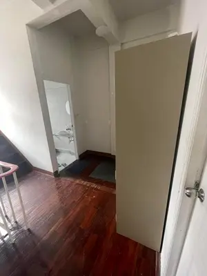 an empty room with a door and a wooden floor at Happy Hope in Bangkok
