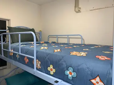 a bed with a blue comforter with animals on it at White House Hostel Khaosan in Bangkok