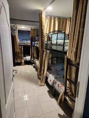 a room with three bunk beds and a doorway at White House Hostel Khaosan in Bangkok