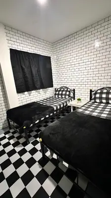 two beds in a room with a checkered floor at White House Hostel Khaosan in Bangkok