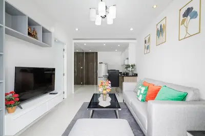 a living room with a couch and a table at Shine Sukhumvit 43 Apathotel Phrompong in Bangkok
