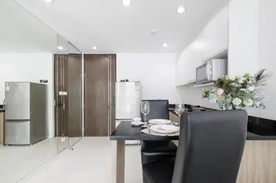 a kitchen with a table with chairs and a refrigerator at Shine Sukhumvit 43 Apathotel Phrompong in Bangkok