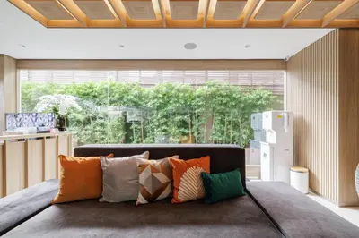 a living room with a couch with colorful pillows at Shine Sukhumvit 43 Apathotel Phrompong in Bangkok