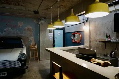 a bar with a car parked in a room with lights at Silom Soi 3 Hash Apartment in Bangkok