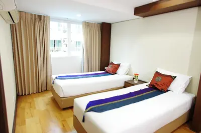 a hotel room with two beds and a window at The Ninth Place Serviced Residence in Bangna