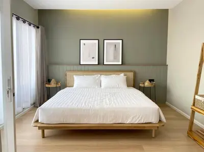 a bed in a bedroom with two pictures on the wall at Vélin Khaosan - 4th Floor apartment with 2Bedrooms in Bangkok