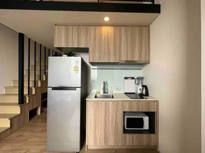 a kitchen with a refrigerator and a counter with a microwave at S87-7052 BTS Onnut High Floor Gym Swim Good View in Bangkok