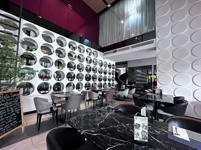 a restaurant with tables and chairs and a wall with plates at S87-7052 BTS Onnut High Floor Gym Swim Good View in Bangkok
