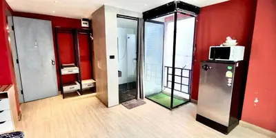 a room with red walls and a refrigerator and a microwave at Hash Apartment Silom Soi 3 - hip and funky with rooftop view in Bangkok