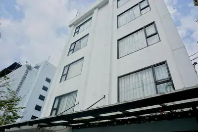 a white building with windows on the side of it at Hash Apartment Silom Soi 3 - hip and funky with rooftop view in Bangkok