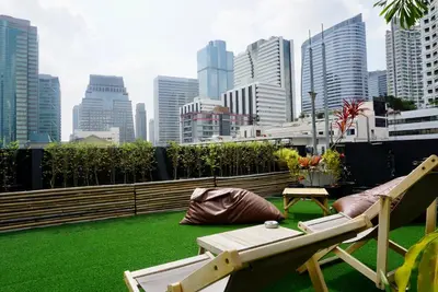 a patio with a chaise lounge and a bench on a roof at Hash Apartment Silom Soi 3 - hip and funky with rooftop view in Bangkok