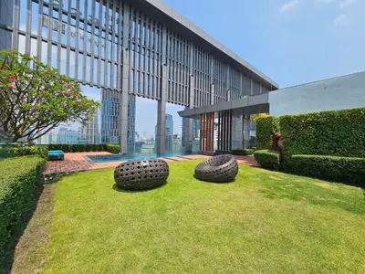 two large tires sitting in the grass in front of a building at The Address 28 in Bangkok