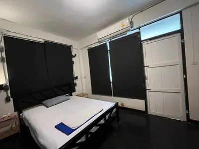 a bedroom with a bed and two large windows at Bangkok Dreamcatcher hostel in Bangkok