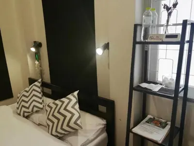 a bedroom with a black and white bed and a shelf at Bangkok Dreamcatcher hostel in Bangkok