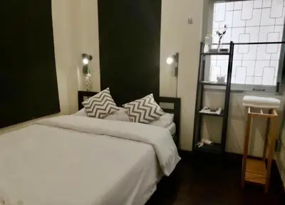a bedroom with a bed with white sheets and a window at Bangkok Dreamcatcher hostel in Bangkok