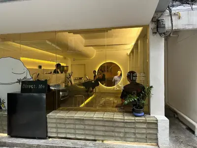 a man sitting in front of a store window at Bangkok Dreamcatcher hostel in Bangkok