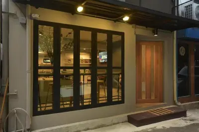 a building with large glass windows and a door at Bangkok Chat box Hostel in Bangkok