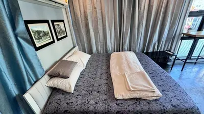 a bedroom with a bed with pillows and a window at Bangkok Chat box Hostel in Bangkok