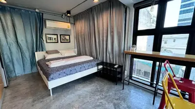 a bedroom with a bed and a desk and windows at Bangkok Chat box Hostel in Bangkok