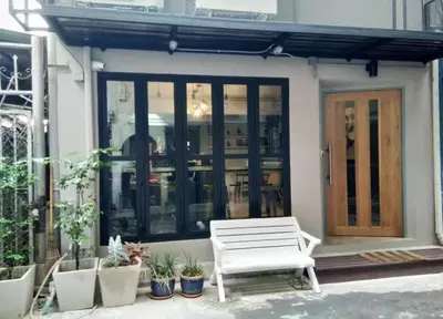 a white bench sitting in front of a house at Bangkok Chat box Hostel in Bangkok