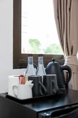 a tray with bottles and cups on a table at Nature Boutique Residence in Bangkok
