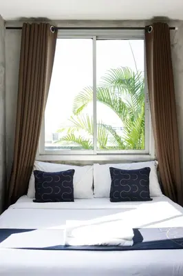 a bed in front of a large window at Nature Boutique Residence in Bangkok