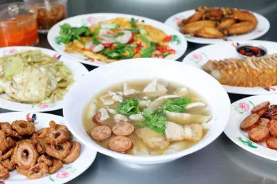 a table with bowls of soup and plates of food at The Character China Town เดอะ คาแรคเตอร์ เยาวราช Mrt วัดมังกร Pro in Khlong San