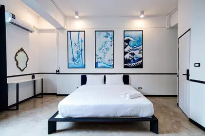 a bedroom with a white bed and paintings on the wall at The Character China Town เดอะ คาแรคเตอร์ เยาวราช Mrt วัดมังกร Pro in Khlong San
