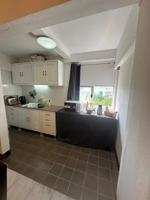 a kitchen with white cabinets and a counter top at Mahasap Ramindhra next to MRT Station in Bang Khen