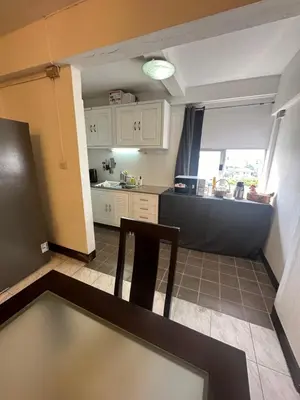 a kitchen with a table and a chair in a room at Mahasap Ramindhra next to MRT Station in Bang Khen