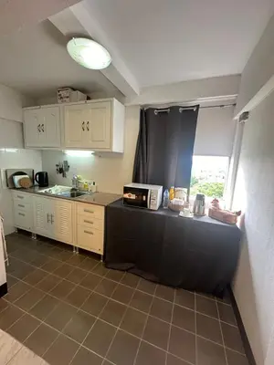 a kitchen with white cabinets and a black counter top at Mahasap Ramindhra next to MRT Station in Bang Khen