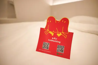 a red shopping bag sitting on a bed at ABC Bangkok RCA in Bangkok
