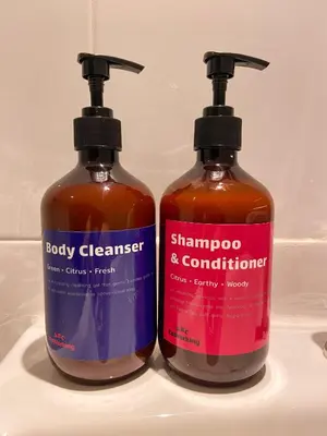 two bottles of shampoo and conditioner sitting on a sink at ABC Bangkok RCA in Bangkok