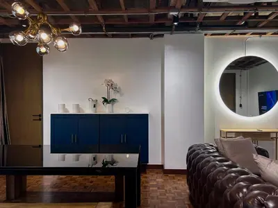 a living room with a couch and a mirror at Brown Brick Thonglor - Blue Blueberry Room in Khlong Toei