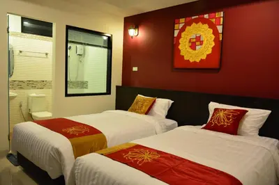two beds in a room with red walls at Adamaz House in Bangkok