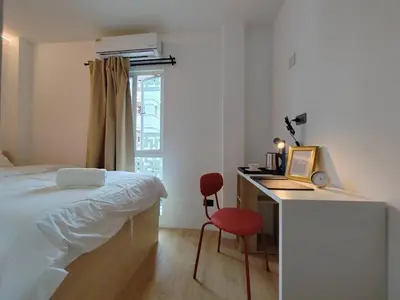 a bedroom with a bed and a desk with a computer at The Motuga Hostel Bangkok in Bangkok