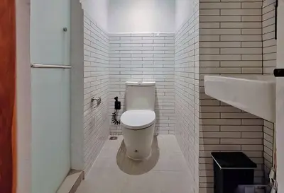 a bathroom with a white toilet and a sink at The Motuga Hostel Bangkok in Bangkok