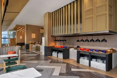a restaurant with a kitchen with a counter top at Hilton Garden Inn Bangkok Riverside in Bangkok