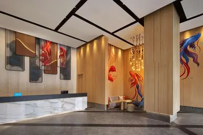 a lobby of a hotel with paintings on the walls at Hilton Garden Inn Bangkok Riverside in Bangkok