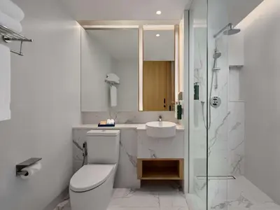 a bathroom with a toilet and a sink and a shower at Hilton Garden Inn Bangkok Riverside in Bangkok