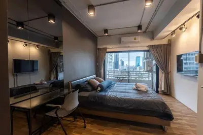 a bedroom with a bed and a desk and a television at Cozy 2BR Duplex-Apartment in Thong Lor in Bangkok