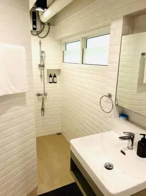 a white bathroom with a sink and a shower at Cozy 2BR Duplex-Apartment in Thong Lor in Bangkok