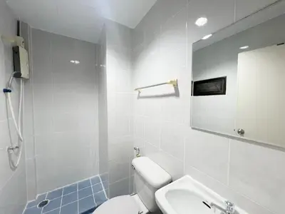 a bathroom with a toilet and a sink and a mirror at V Reserve at Merry V in Bangkok