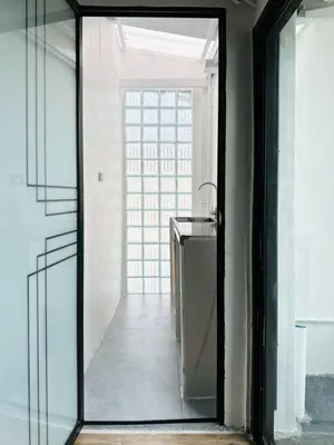 a glass door leading to a hallway with a sink at Megun 10 in Ban Bang Phlat