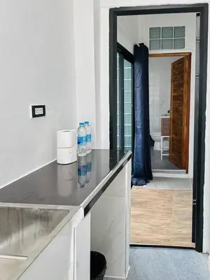a kitchen with two bottles of water on a counter at Megun 10 in Ban Bang Phlat